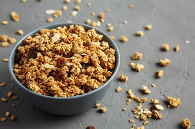 Gri arka planda kuru üzüm ve bademli ev yapımı granola. Boşluğu kopyala.