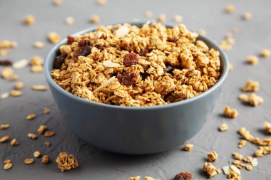 Gri arka planda kuru üzüm ve bademli ev yapımı granola. Yakın plan..