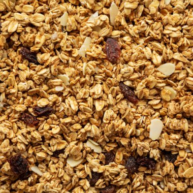 Kuru üzüm ve badem arkaplanlı ev yapımı granola, üst manzara. Dümdüz, tepeden, yukarıdan.