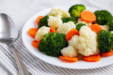 Beyaz ahşap bir arka planda, havuç, brokoli ve karnabahar gibi karışık organik sebzeler. Yakın plan..