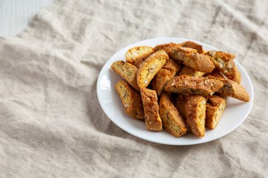 Beyaz tabakta badem soslu ev yapımı İtalyan Cantuccini. Çıtır bademli kurabiyeler. Boşluğu kopyala.