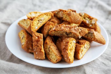 Beyaz tabakta badem soslu ev yapımı İtalyan Cantuccini. Çıtır bademli kurabiyeler. Yakın plan..