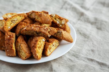 Beyaz tabakta badem soslu ev yapımı İtalyan Cantuccini. Çıtır bademli kurabiyeler. Metin için boşluk.