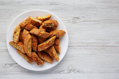Beyaz ahşap arka planda, badem kaplı ev yapımı İtalyan Cantuccini. Çıtır bademli kurabiyeler. Dümdüz, tepeden, yukarıdan. Boşluğu kopyala.