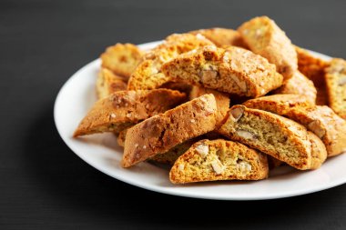 Siyah arka planda badem kaplı ev yapımı İtalyan Cantuccini. Çıtır bademli kurabiyeler. Yakın plan..