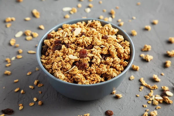 Gri arka planda kuru üzüm ve bademli ev yapımı granola.. 