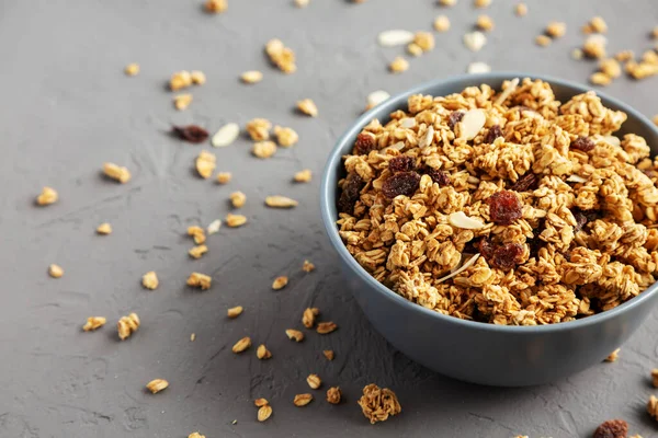 Gri arka planda kuru üzüm ve bademli ev yapımı granola. Metin için boşluk.