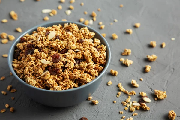 Gri arka planda kuru üzüm ve bademli ev yapımı granola. Boşluğu kopyala.
