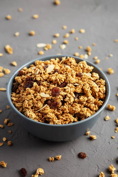 Gri arka planda kuru üzüm ve bademli ev yapımı granola.. 