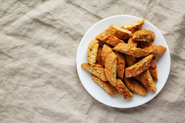 Beyaz tabakta badem soslu ev yapımı İtalyan Cantuccini. Çıtır bademli kurabiyeler. Dümdüz, tepeden, yukarıdan. Metin için boşluk.