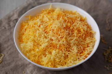 Beyaz kasede doğranmış Meksika peyniri karışımı, düşük açılı. Yakın plan..