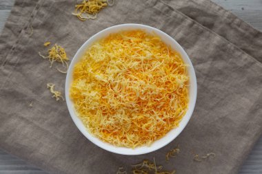 Beyaz kasede doğranmış Meksika peyniri karışımı. Manzaralı. Dümdüz, tepeden, yukarıdan.