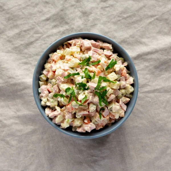 Ev yapımı Olivier salatası, beyaz ahşap arka planda, üst manzara. Dümdüz, tepeden, yukarıdan. 