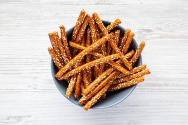 Beyaz ahşap arka planda fırında kraker ve susam çubukları, üst manzara. Dümdüz, tepeden, yukarıdan. 