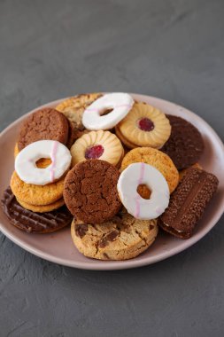 Pembe tabakta çeşitli bisküviler, yan manzara. 