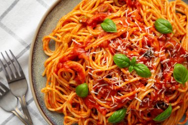 Tabakta zeytin ve domates soslu ev yapımı spagetti. Dümdüz, tepeden, yukarıdan. Yakın plan..