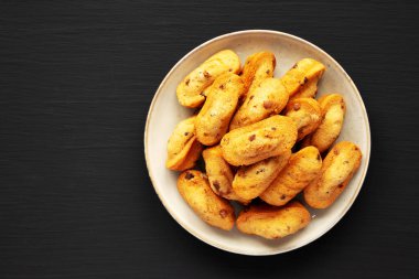 Siyah arka planda, Tabakta ev yapımı çikolatalı kurabiyeler, üst manzara. Dümdüz, tepeden, yukarıdan. Boşluğu kopyala.