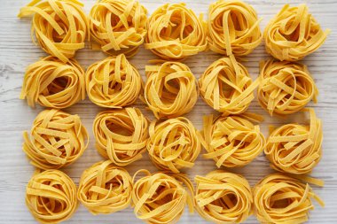 Beyaz ahşap arka planda ev yapımı organik Tagliatelle Makarnası.. 