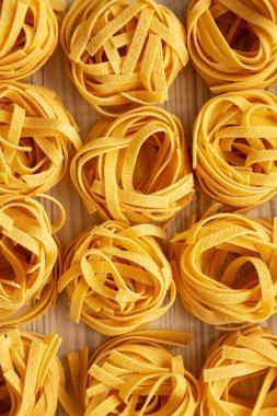 Beyaz ahşap arka planda ev yapımı organik Tagliatelle Makarnası. Dümdüz, tepeden, yukarıdan.