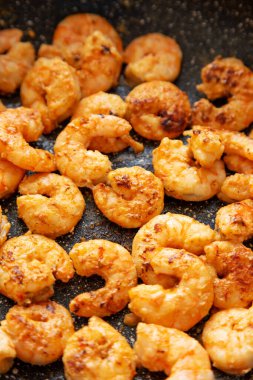 Kızartma tavasında karides pişirmek, düşük açı. Yakın plan..