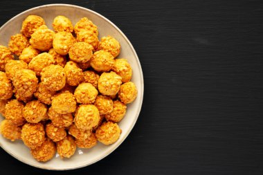 Siyah bir yüzeyde, üzerinde Parmigiano Reggiano olan ev yapımı gevrek bisküviler. Dümdüz, tepeden, yukarıdan. Boşluğu kopyala.