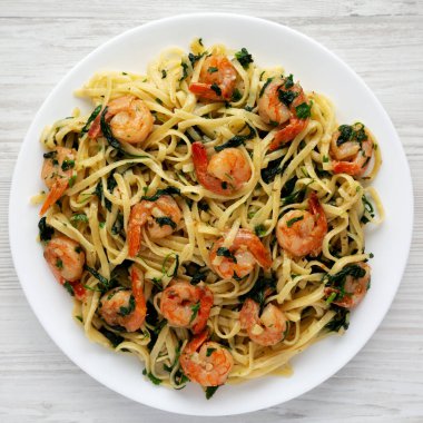 Beyaz ahşap arka planda tek katlı limonlu sarımsaklı karides makarna. Dümdüz, tepeden, yukarıdan.