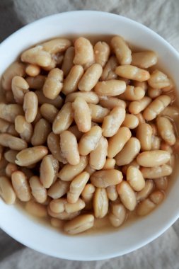 Beyaz Kasedeki Organik Beyaz Cannellini Fasulyeleri. Dümdüz, tepeden, yukarıdan.