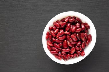 Kırmızı Organik Böbrek Fasulyesi, siyah arka planda, üst tarafta. Dümdüz, tepeden, yukarıdan. Boşluğu kopyala.