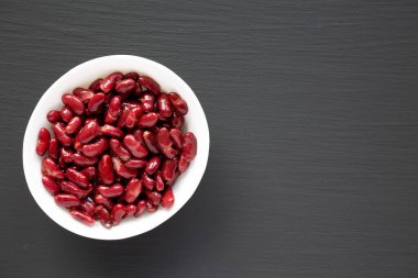 Kırmızı Organik Böbrek Fasulyesi, siyah arka planda, üst tarafta. Dümdüz, tepeden, yukarıdan. Boşluğu kopyala.