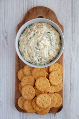 Ev yapımı karamelli soğan ve tuzlu krakerli ıspanak dalışı. Dümdüz, tepeden, yukarıdan. 