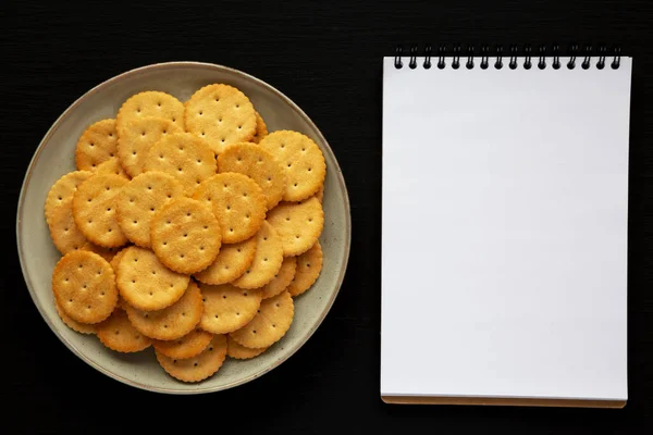 Salty Crackers Plate Blank Notepad Black Background Top View Flat — ストック写真