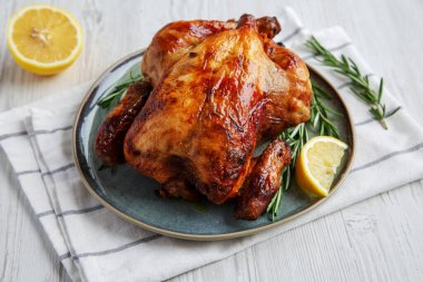 Homemade Lemon and Herb Rotisserie Chicken on a Plate, side view.
