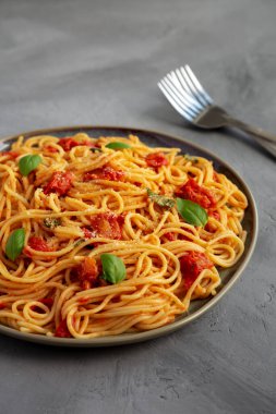 Gri arka planda taze domates soslu ev yapımı spagetti makarna. Yakın plan..