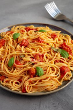 Gri arka planda taze domates soslu ev yapımı spagetti makarna. Yakın plan..