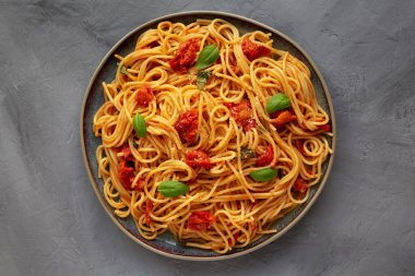 Gri arka planda taze domates soslu ev yapımı spagetti makarna, üst manzara. Dümdüz, tepeden, yukarıdan.