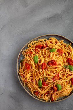 Gri arka planda taze domates soslu ev yapımı spagetti makarna, üst manzara. Dümdüz, tepeden, yukarıdan.