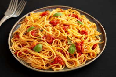 Siyah bir tabakta taze domates soslu ev yapımı spagetti makarna.. 