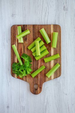 Ahşap bir tahta üzerinde çiğ organik kereviz, beyaz ahşap arka plan, üst manzara. Dümdüz, tepeden, yukarıdan. 