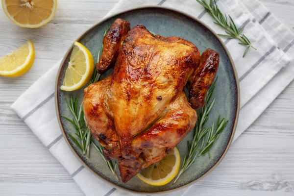 Ev yapımı limon ve Herb Rotisserie Chicken tabakta, en iyi manzara. Dümdüz, tepeden, yukarıdan. Yakın plan..