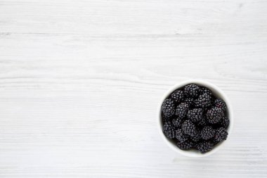 Raw Blackberries in a Bowl, top view. Flat lay, overhead, from above. Copy space.