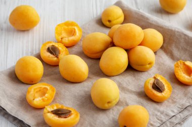 Raw White Apricot Angelcots on a white wooden background, side view. 