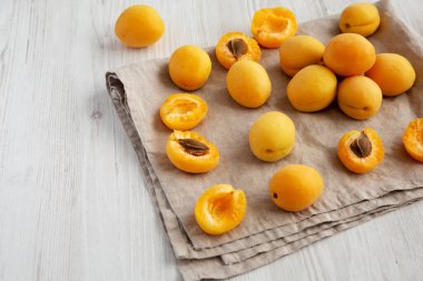 Raw White Apricot Angelcots on a white wooden background, top view. Flat lay, overhead, from above. Copy space.