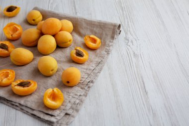 Raw White Apricot Angelcots on a white wooden background, low angle view. Copy space.
