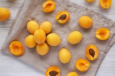 Raw White Apricot Angelcots on a white wooden surface, top view. Flat lay, overhead, from above.