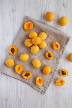 Raw White Apricot Angelcots on a white wooden background, top view. Flat lay, overhead, from above.