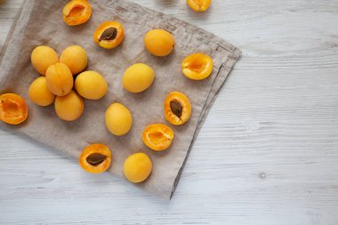 Raw White Apricot Angelcots on a white wooden background, top view. Flat lay, overhead, from above. Copy space.
