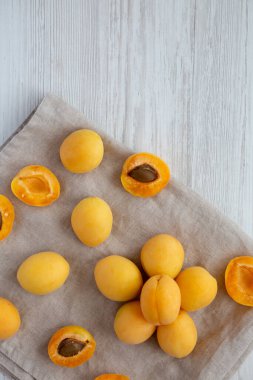 Raw White Apricot Angelcots on a white wooden surface, top view. Flat lay, overhead, from above. Copy space.
