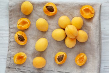 Raw White Apricot Angelcots on a white wooden surface, top view. Flat lay, overhead, from above. 