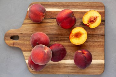 Raw Organic Yellow Peaches on a wooden board, top view. Flat lay, overhead, from above. 