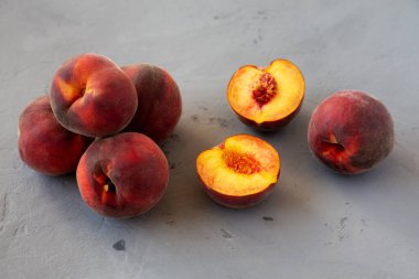 Raw Organic Yellow Peaches on a gray background, side view.